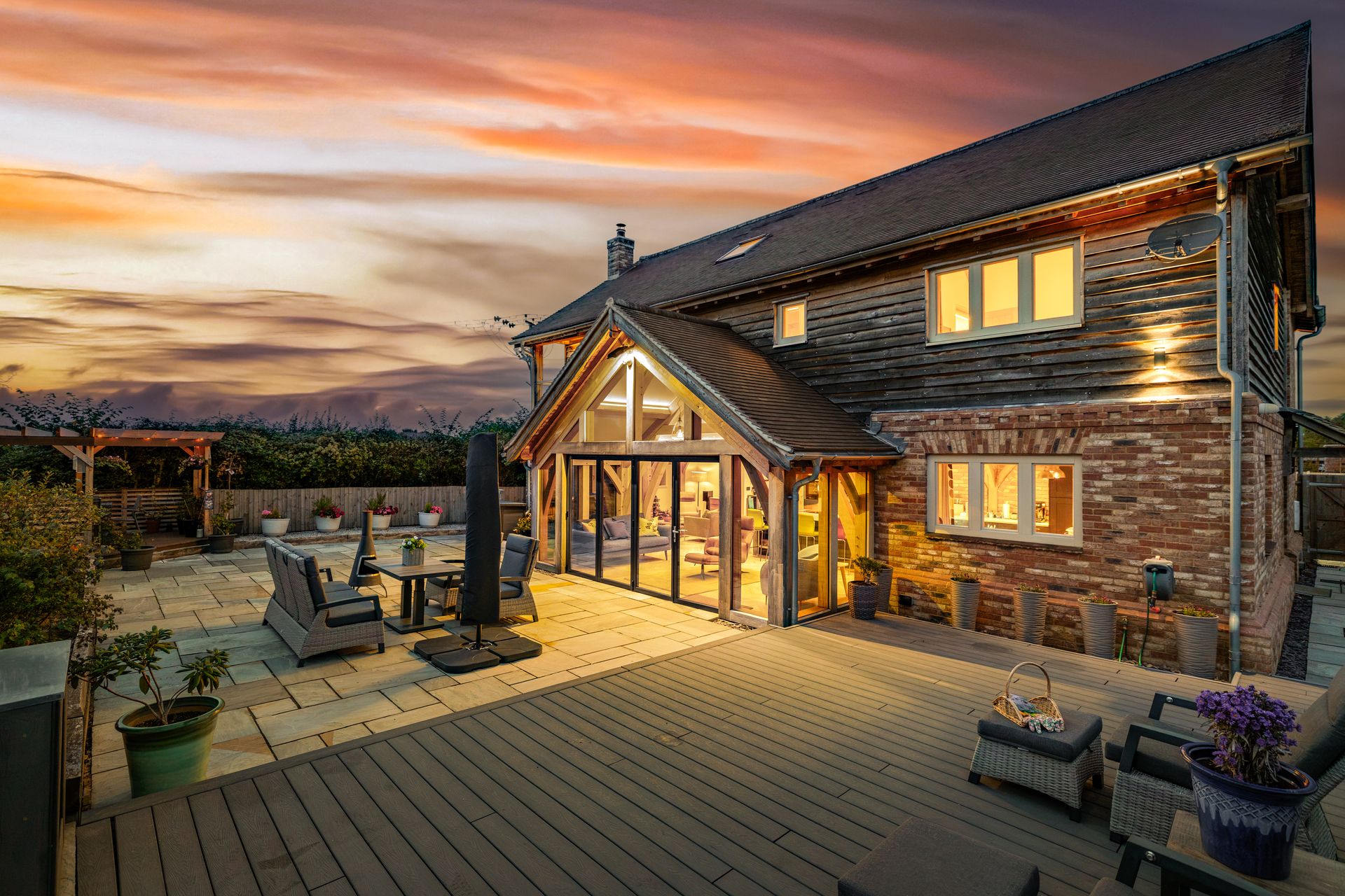 The Oak House terrace at dusk, lit for evening entertaining